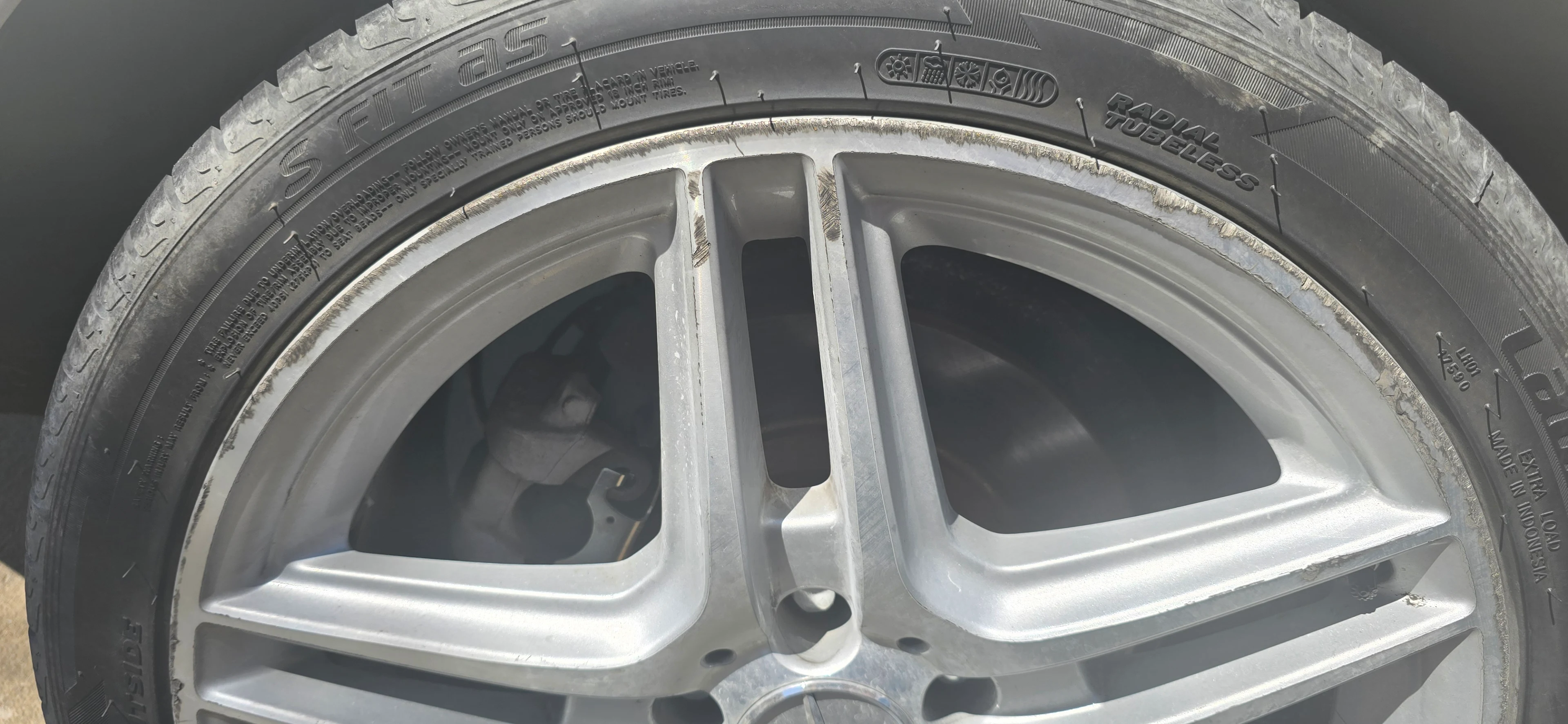 Curb-scraped factory alloy wheel before refinishing